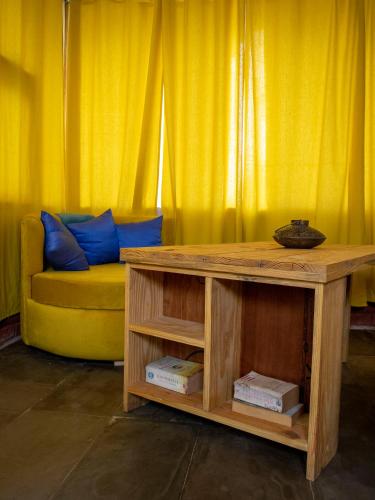 a living room with a table and a yellow couch at Aranya by Stories in Jaipur