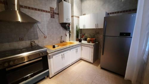 a kitchen with a stainless steel refrigerator and a sink at Appartement Centre Ville Avenue Loubet in Oran