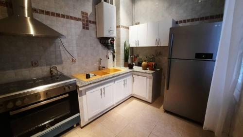 a kitchen with a stainless steel refrigerator and a sink at Appartement centre ville in Oran
