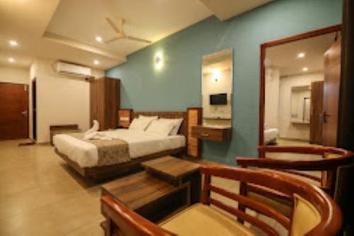 een slaapkamer met een bed, een tafel en een spiegel bij Misty Gate Kerala in Vythiri