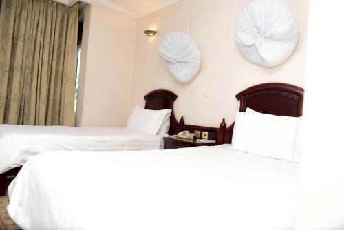 two beds in a hotel room with hearts on the wall at Room in BB - This Twin room is a wandeful selection in Kigali