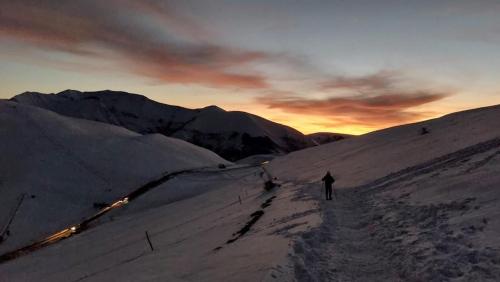 a person is walking down a snow covered slope at Palazzo Rossi, Historic Boutique Home in Marche in Sarnano