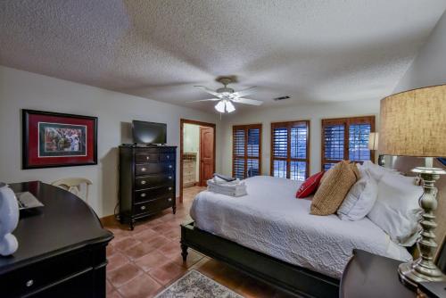 Dormitorio con cama, escritorio y TV en Myrtlewood Cottage, en Tuscaloosa