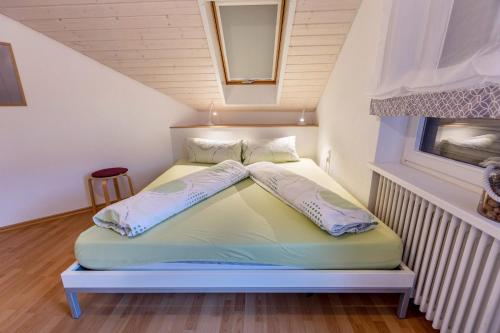 Cama en habitación pequeña con ventana en Ferienwohnungen Haus Birgit, en Günzgen