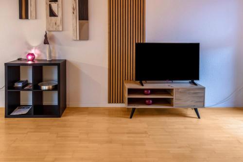 a living room with a tv on a dresser at Ferienwohnungen Haus Birgit in Günzgen