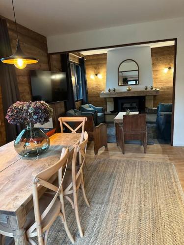 un salon avec une table avec un vase de fleurs dessus dans l'établissement Chalet de l'Ailly, à Varengeville-sur-Mer