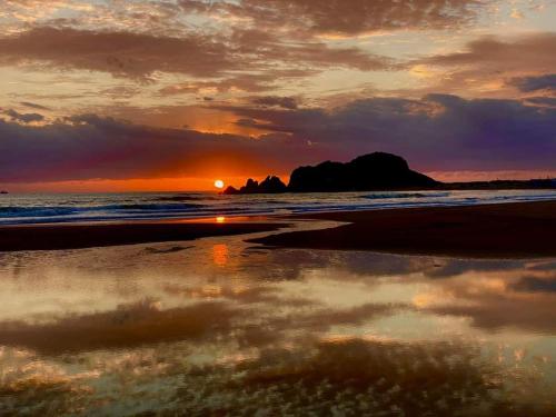 a sunset on the beach with a reflection in the water at Alessi Suites & Studio in Mazzarino