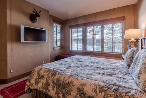 a bedroom with a bed and a flat screen tv at Westridge Condo 27 - Cozy Condo Walk to Bald Mt and Downtown Ketchum in Ketchum