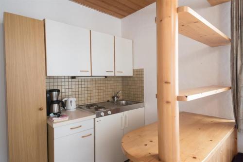 a small kitchen with white cabinets and a sink at Appartementhaus Renate Unterer in Kelchsau