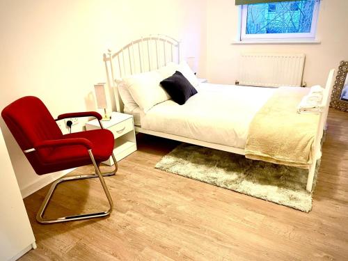 1 dormitorio con 1 cama y 1 silla roja en Peaceful Impeccable 2-Bed Apartment in Hatfield en Hatfield