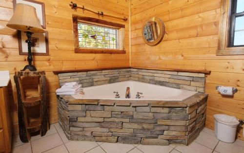 baño con bañera grande en una cabaña de madera en Moonlit Hideaway, en Sevierville