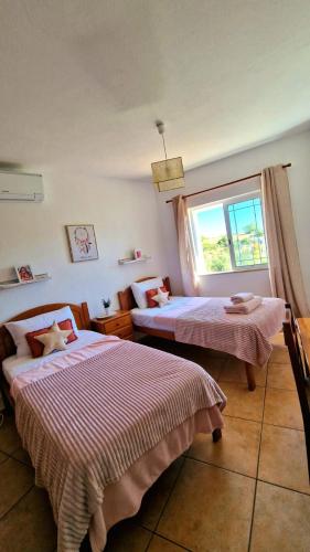a bedroom with two beds and a window at Villa Carpe Diem (Seize the day) in Carvoeiro