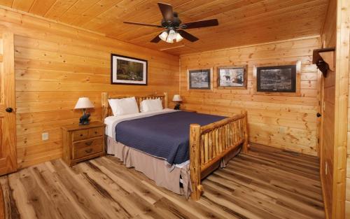 1 dormitorio con 1 cama y ventilador de techo en Moonlit Hideaway, en Sevierville