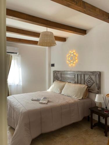 1 dormitorio con 1 cama grande y cabecero de madera en Trullo Santa Lucia, en Cisternino