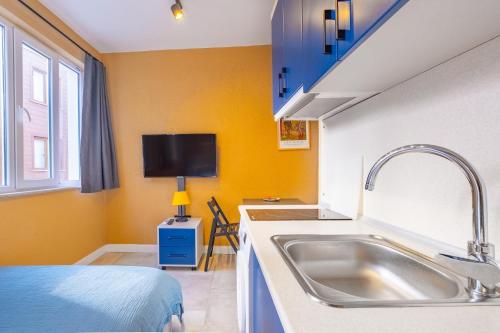 a kitchen with a sink and a tv on the wall at Central Furnished Studio 5 min to Coast in Fatih in Istanbul