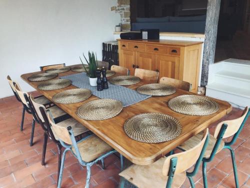 a long wooden table with chairs and plates on it at Luxury Chateau w. pool & hot tub in Dordogne in Cazenac