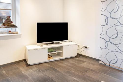 a television on a white cabinet in a room at Ferienwohnungen Haus Birgit in Günzgen