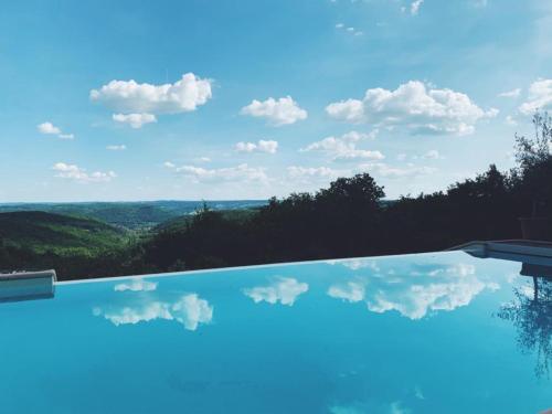 een zwembad met uitzicht op de lucht bij Luxury Chateau w. pool & hot tub in Dordogne in Cazenac