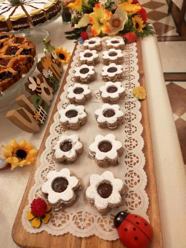 a tray of pastries on a table with flowers at Les 7 Suites Erica in Grado