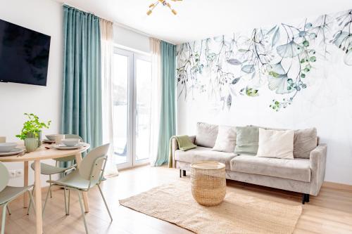 uma sala de estar com um sofá e uma mesa em Apartamenty Sea Colors - Nowoczesne i Komfortowe Apartamenty w Jastrzębiej Górze em Jastrzebia Gora