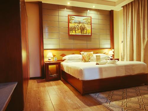 pokój hotelowy z łóżkiem i ścianą w obiekcie Great Wall Hotel w mieście Dar es Salaam
