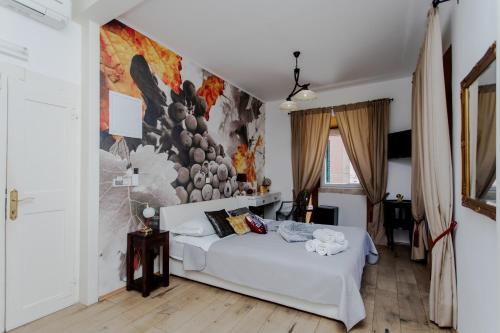 una camera con un letto bianco e un dipinto sul muro di Guesthouse Mimbelli a Orebić (Sabbioncello)