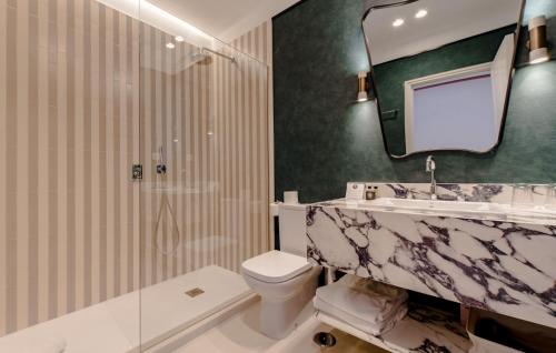 een badkamer met een wastafel, een toilet en een spiegel bij Apartamentos Soho Boutique Hoy No Me Puedo Levantar in Madrid