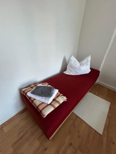 a bed in a room with a red blanket and pillow at Stadtoase in Lichtenstein