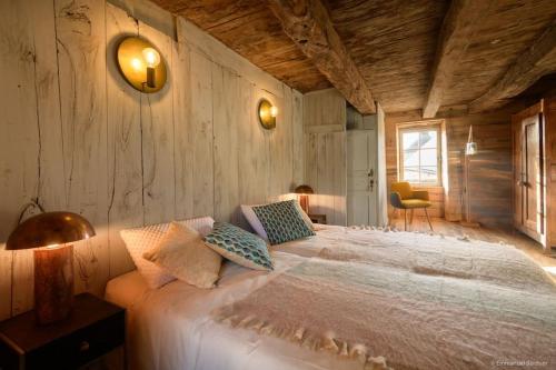 una camera da letto con un letto bianco con una parete di legno di Gîte bien être et écologique Le Jardin intérieur a Saint-Congard