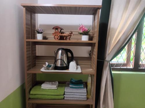 a wooden shelf with a tea kettle and towels at Lovely FLowers in Mount Lavinia in Mount Lavinia