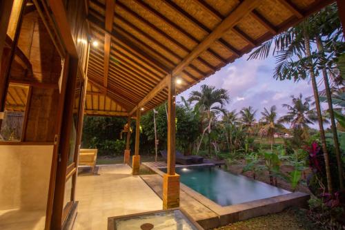 een patio met een zwembad in een huis bij Bale D'Uma Joglo in Ubud