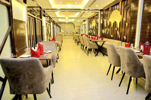 Un comedor con mesas y sillas en un restaurante. en Pineberry Hotels - Near Golden Temple, en Amritsar