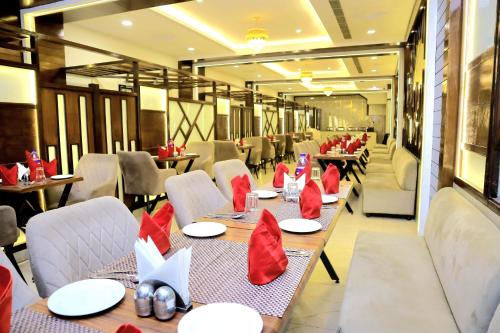 a restaurant with tables and chairs with red napkins on them at Pineberry Hotels in Amritsar