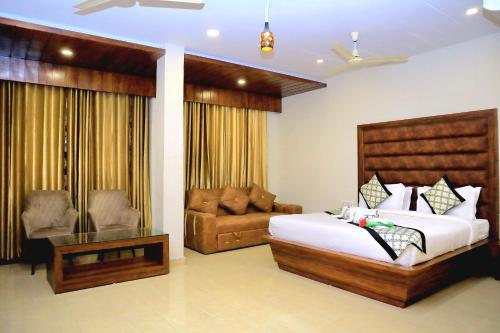 a hotel room with a bed and a couch at Pineberry Hotels in Amritsar
