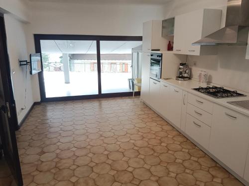 a kitchen with white cabinets and a tile floor at Terrace Home in Saint Vincent