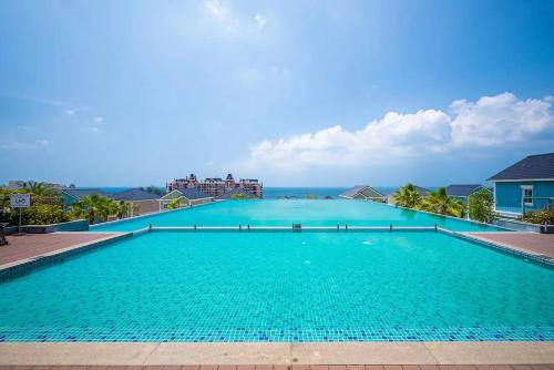 a large swimming pool with the ocean in the background at Seamoni Seaview Villa 01 - Novaworld Phan Thiết in Phan Thiet