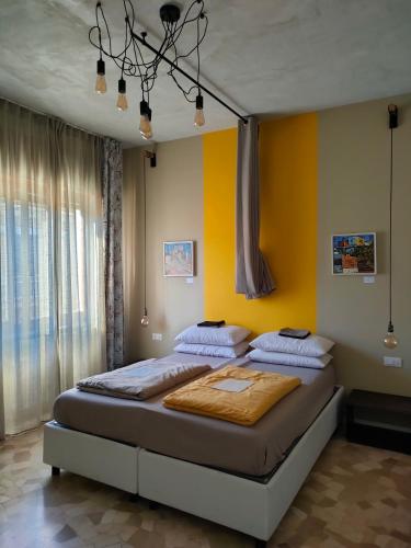 a bedroom with a large bed with yellow walls at Zeljko's luxury hostel in Vicenza