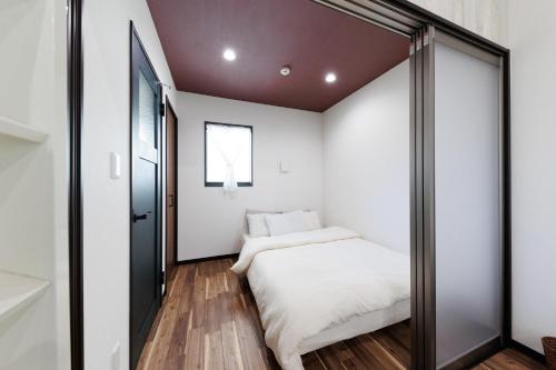 a small bedroom with a bed and a mirror at 西九条 CHILL - Nishikujo CHILL in Osaka