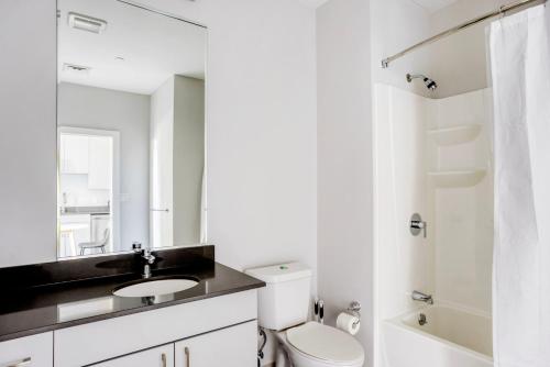 a bathroom with a toilet and a sink and a mirror at Brighton 2br w gym nr green line dining BOS-982 in Boston