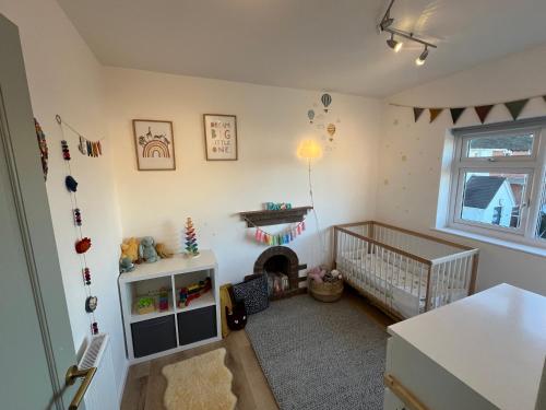 um quarto para bebés com um berço e um berço em Jamie's Braunton, 4 Bedroom family home em Braunton