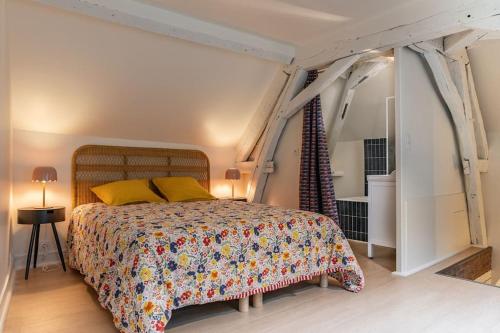 Un dormitorio con una cama grande con almohadas amarillas. en Duplex avec patio - Quartier historique, en Moulins