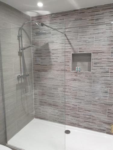 a shower with a glass door in a bathroom at The White Horse Lodge Hotel in Thirsk