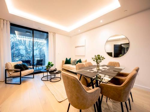 uma sala de estar com uma mesa de jantar e um espelho em Pass the Keys Modern Exuberance and Luxury at Lucent House em Londres