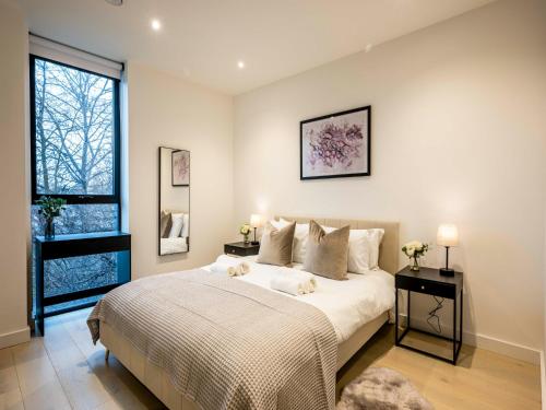 um quarto com uma grande cama branca e uma janela em Pass the Keys Modern Exuberance and Luxury at Lucent House em Londres