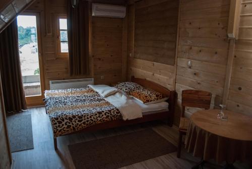 Schlafzimmer mit einem Leopardenbett und einem Tisch in der Unterkunft Hostel Fortuna in Banja Luka