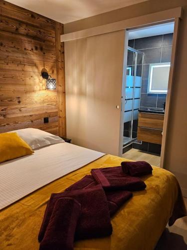 une chambre avec un lit avec une serviette dessus dans l'établissement L'écrin appartement 4 chambres 4 salles d eau, à Les Deux Alpes