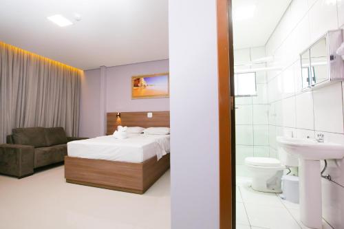 Habitación de hotel con cama y baño en Hotel Cancioneiro, en Sinop