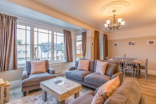 a living room with couches and a table at Sully's Cove, stylish apartment near Southwold Pier in Southwold