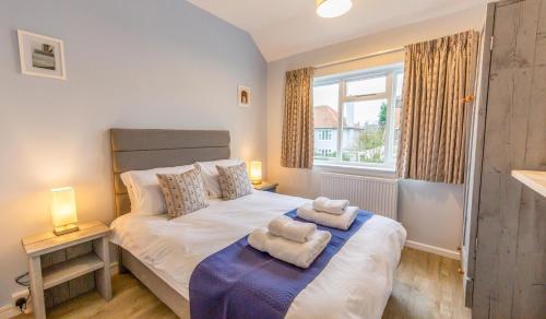 a bedroom with a bed with two towels on it at Sully's Cove, stylish apartment near Southwold Pier in Southwold