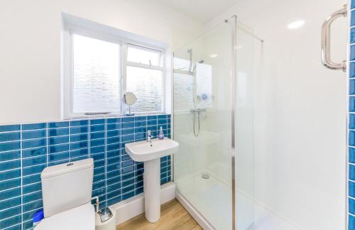 a bathroom with a shower and a toilet and a sink at Sully's Cove, stylish apartment near Southwold Pier in Southwold